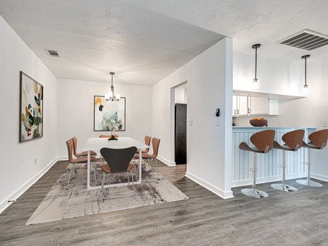 A dining room with a white table and chairs.