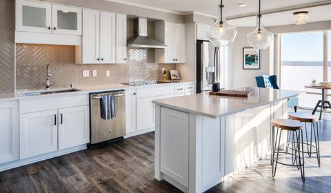 A kitchen with white cabinets and a wooden island.