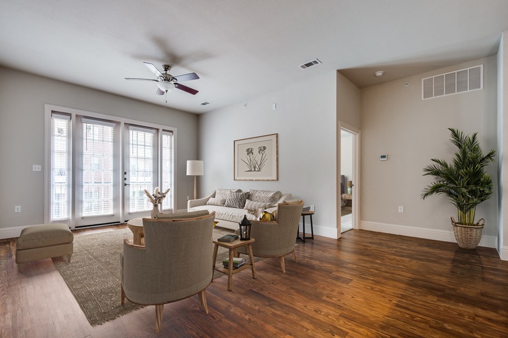 a living room with a couch and chairs and a ceiling fan