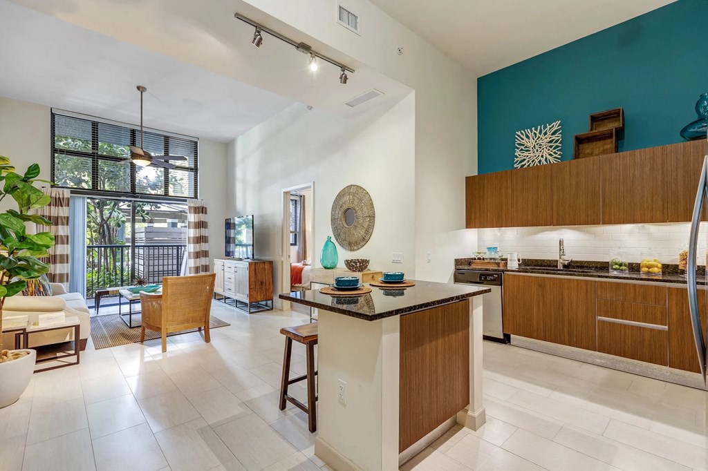 a kitchen and living room with a blue accent wall