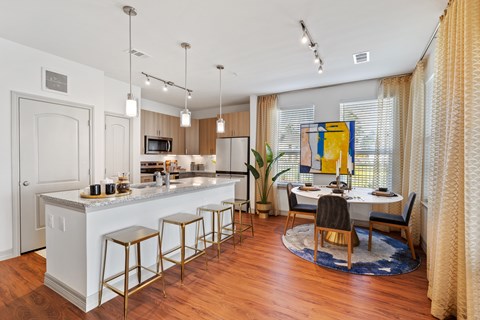 A kitchen with a white counter and bar stools.
