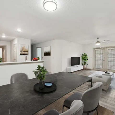 A modern dining room with a black table and grey chairs.