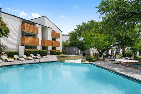 a swimming pool in front of a building with a resort style pool