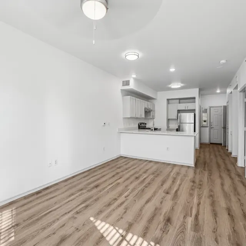 A kitchen with white cabinets and a wooden floor.