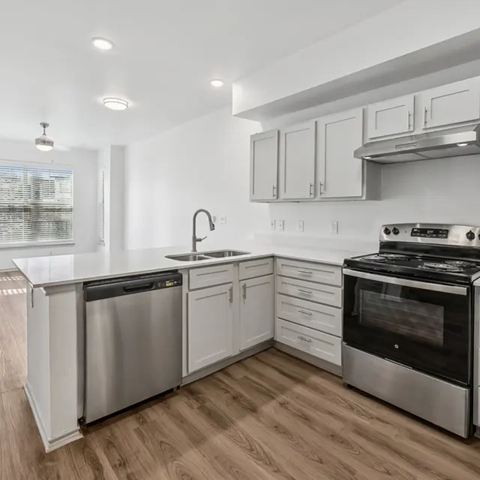 A modern kitchen with stainless steel appliances and white cabinets.