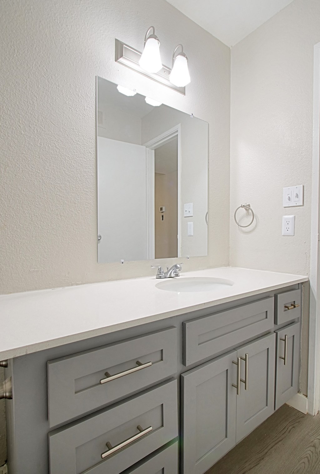 a bathroom with gray cabinets and white countertops