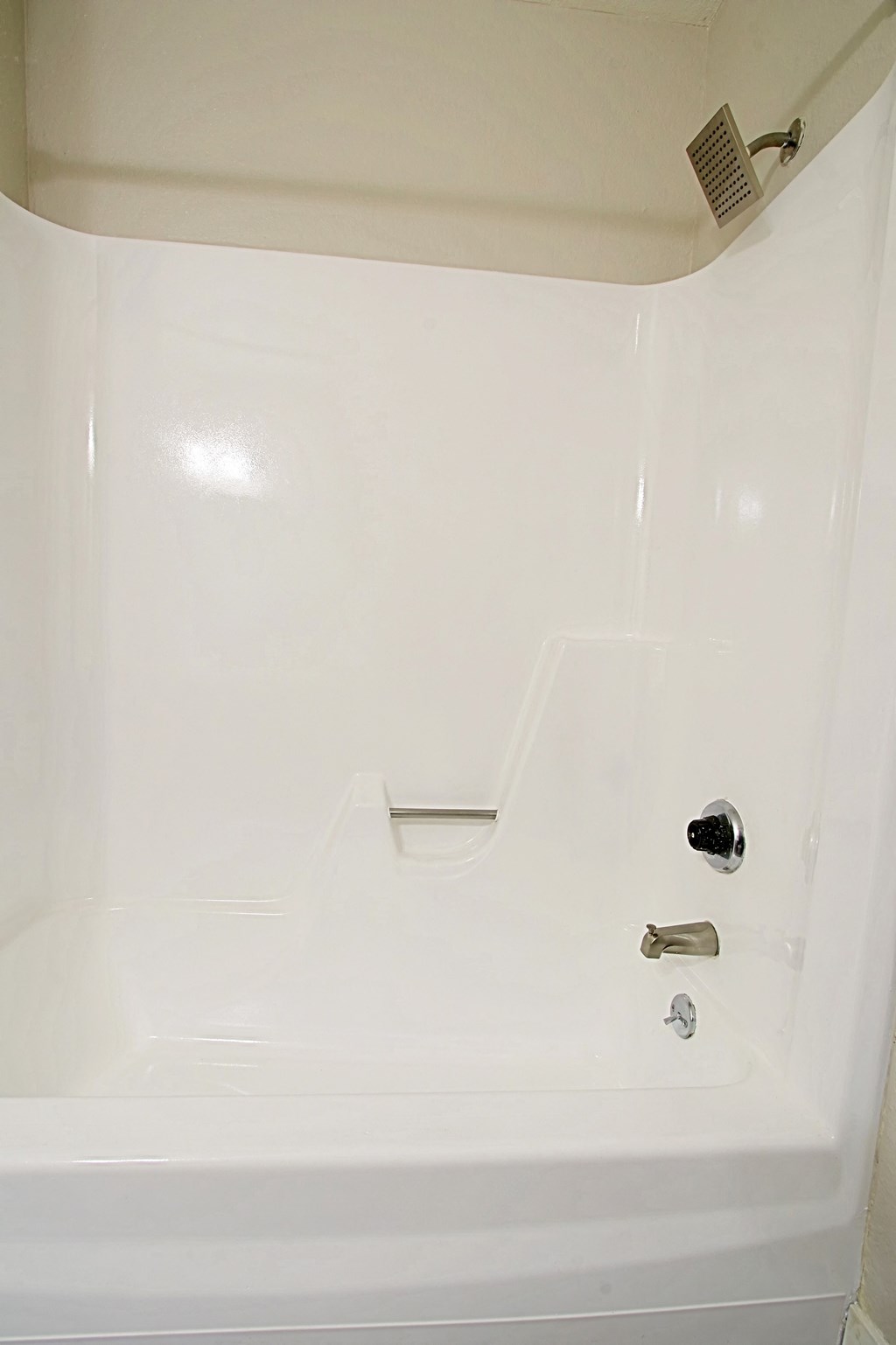 a white bathtub with a silver shower head