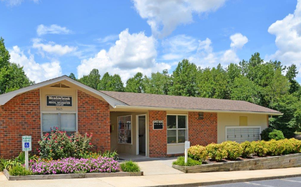 the front of a brick building with flowers in front