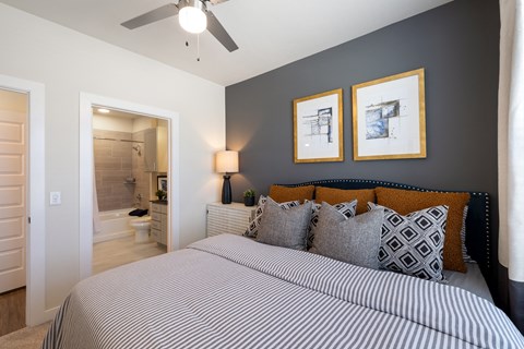 A bedroom with a large bed and two framed pictures on the wall.