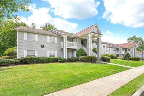 Apartment building number 4 is grey with a red roof.