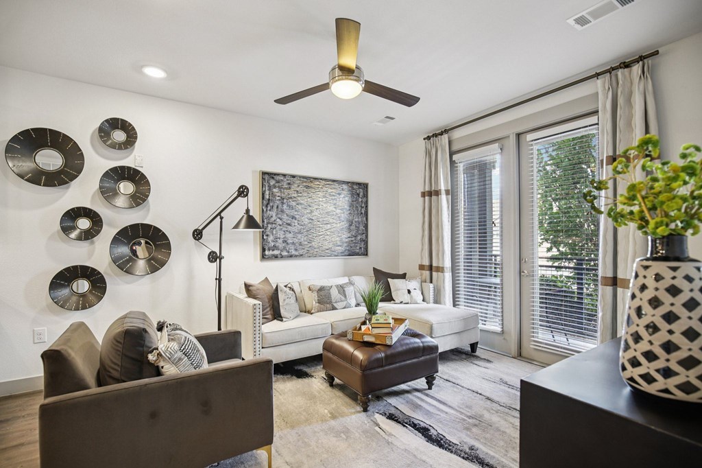 A living room with a brown couch, a white sofa, and a black and white vase.