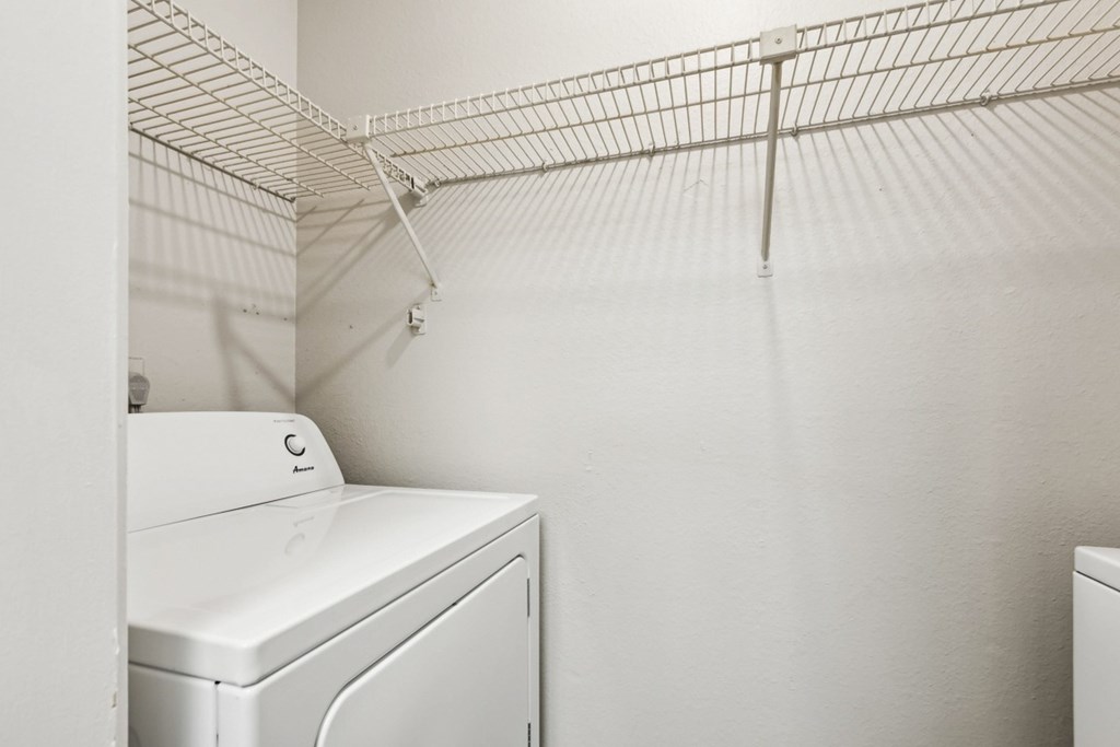 A white washing machine sits in a laundry room.