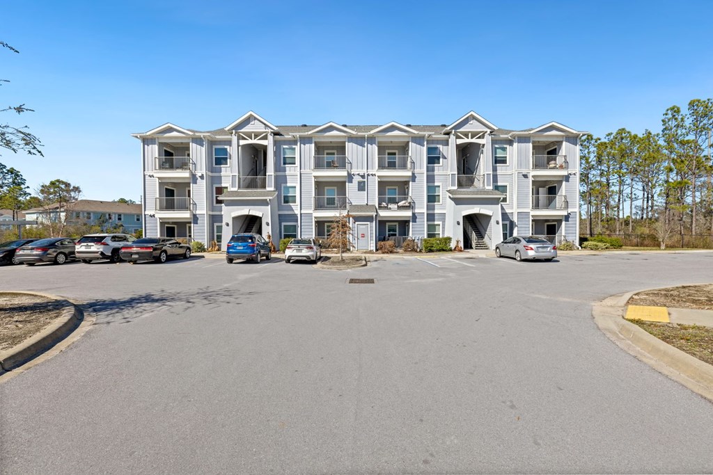 an empty parking lot in front of an apartment building