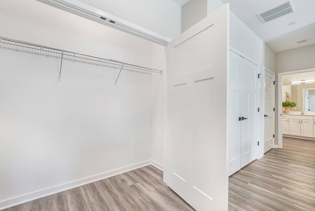 A white closet with a white door and a white wall.