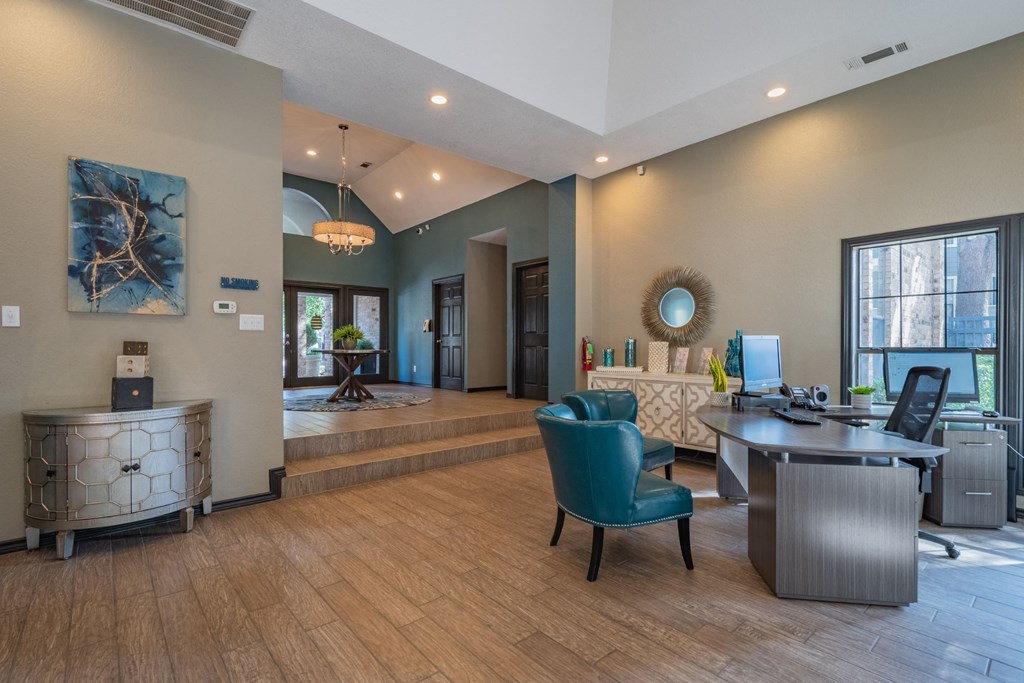 an office with a desk and chairs and a large window