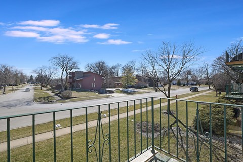 the view from the balcony of a house on a city street