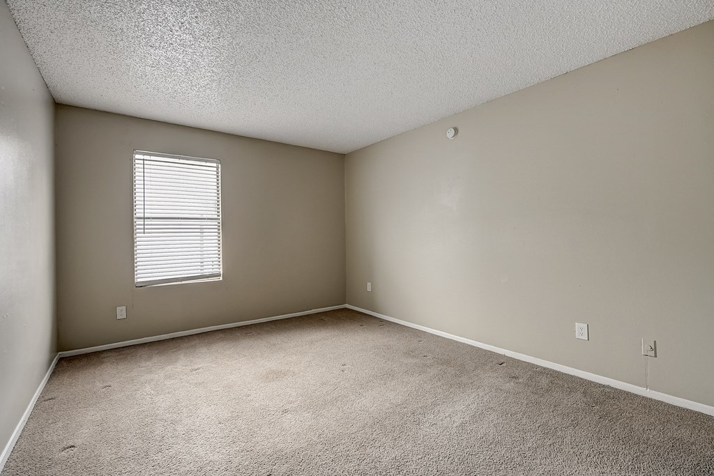 a bedroom with gray walls and a window