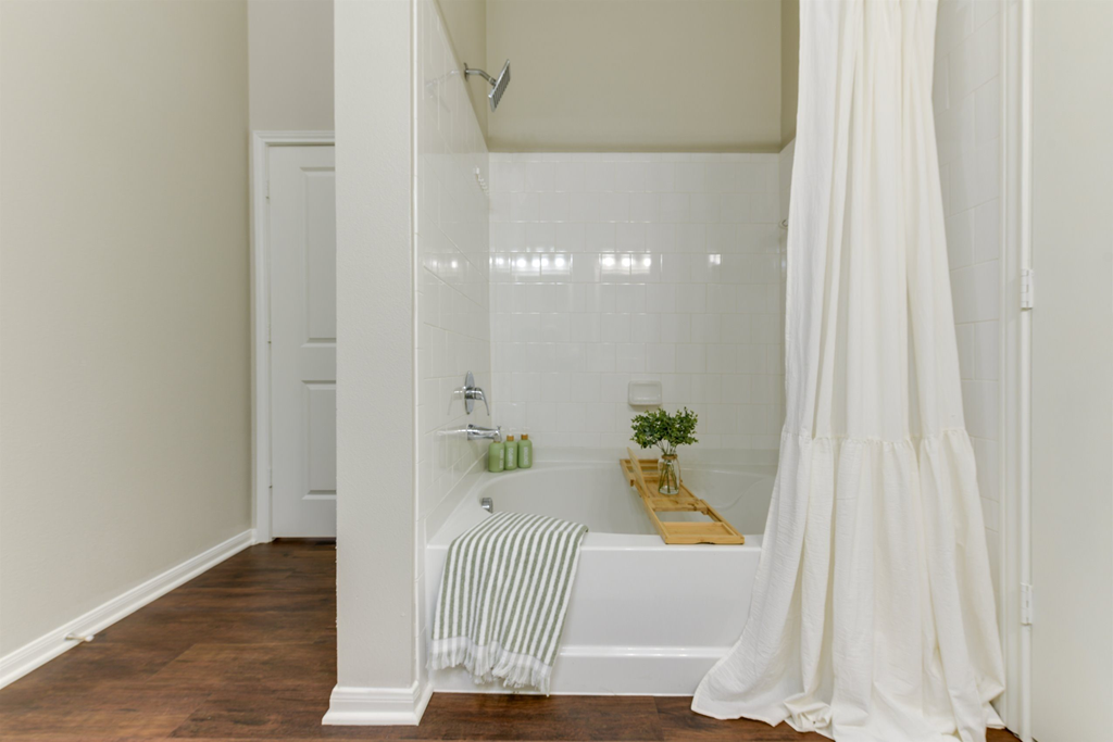 a white bathroom with a tub and a shower curtain
