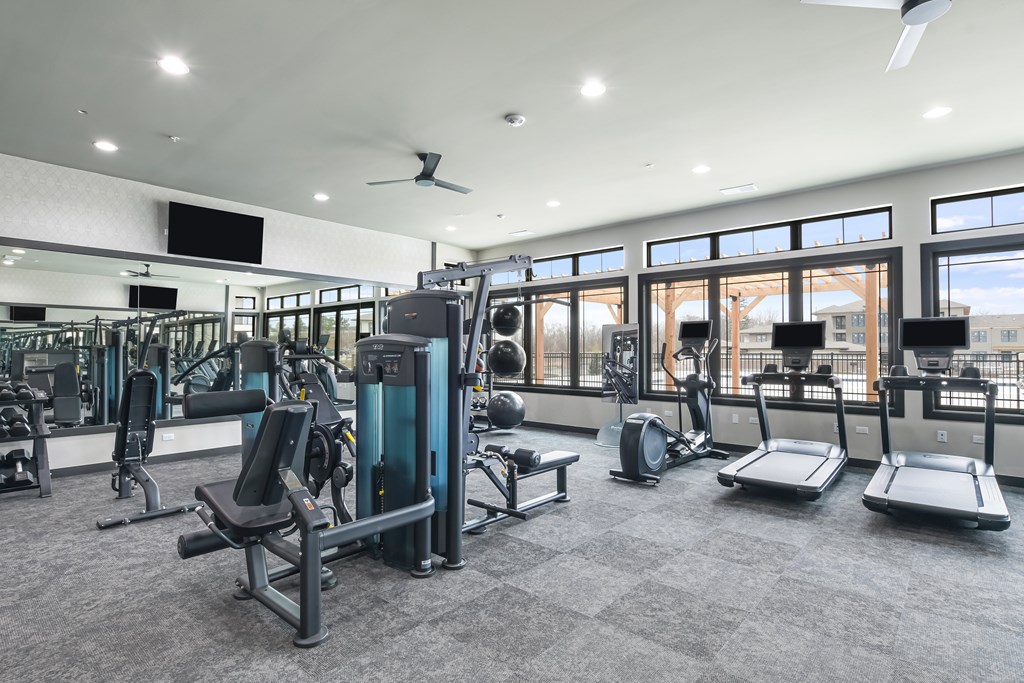A spacious gym with a variety of equipment including treadmills, weights, and exercise machines.