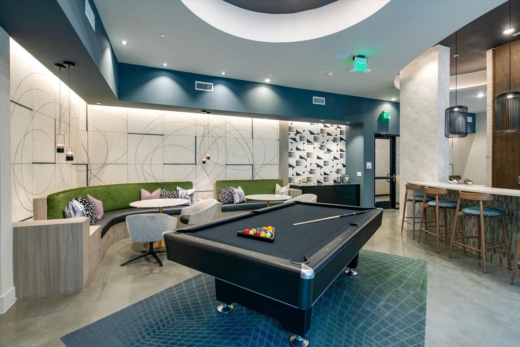 a game room with a pool table and a bar