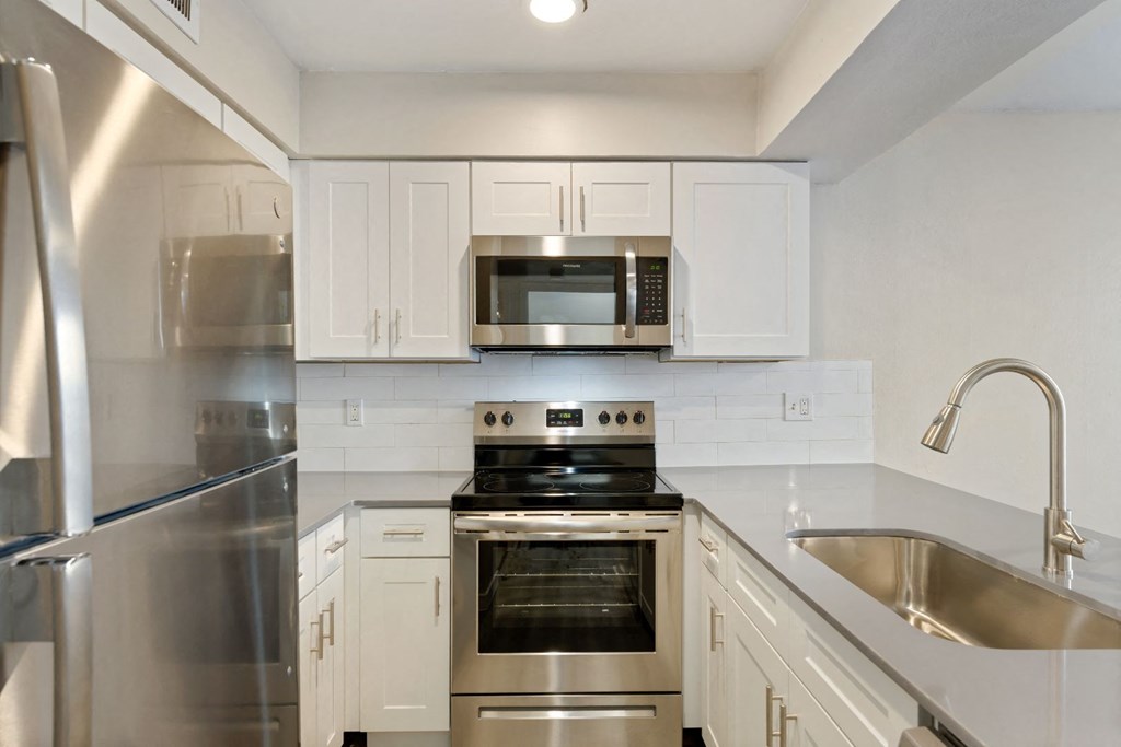a kitchen with white cabinets and stainless steel appliances