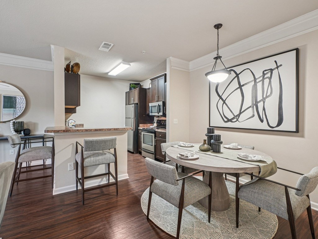 A modern kitchen with a dining table set for two.