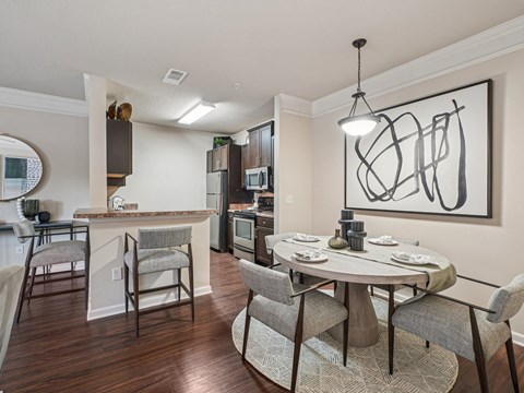 A modern kitchen with a dining table set for two.