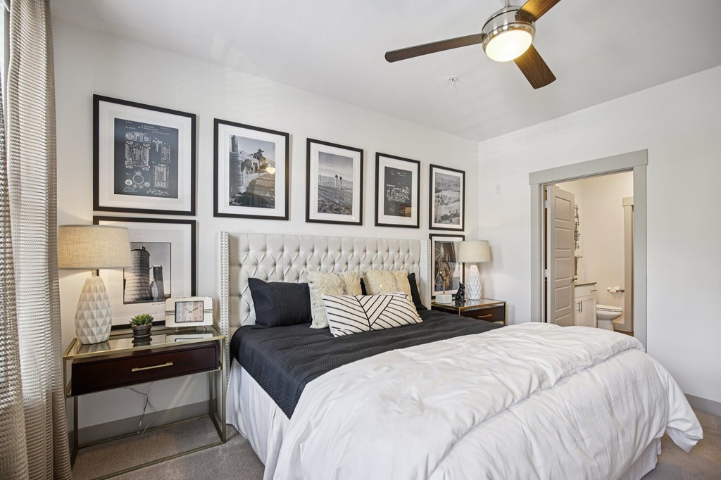 A bedroom with a large bed and a ceiling fan.