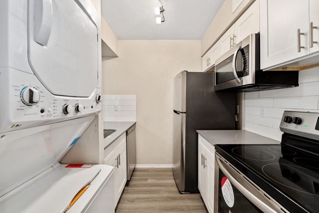 a kitchen with white cabinetry and black appliances