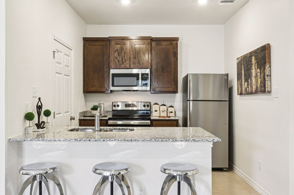 A kitchen with white countertops and a white fridge.