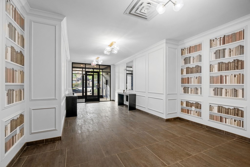 A room with white bookshelves filled with books.