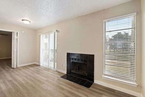 a living room with a fireplace and a large window