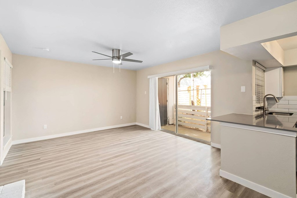 a kitchen and living room with a sliding glass door to a balcony