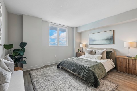 A bedroom with a large bed and a painting on the wall.