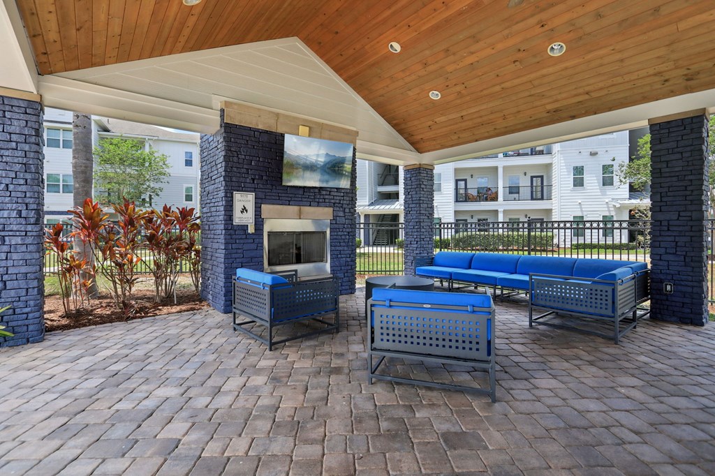 A patio with a grill and seating area.