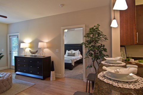 A modern bedroom with a large bed and a dining table set for two.