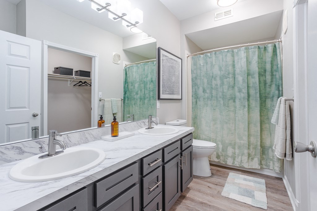 A bathroom with a white sink and a green shower curtain.