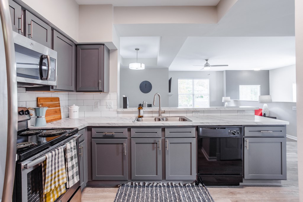 A modern kitchen with dark brown cabinets and a white countertop.