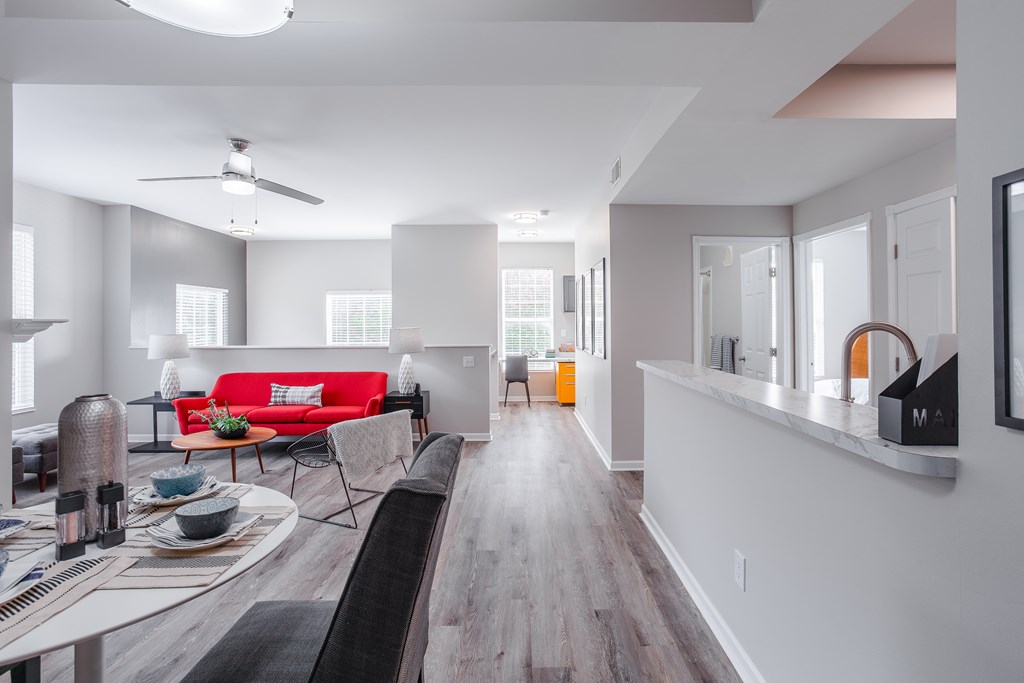 A modern living room with a red couch and a wooden floor.