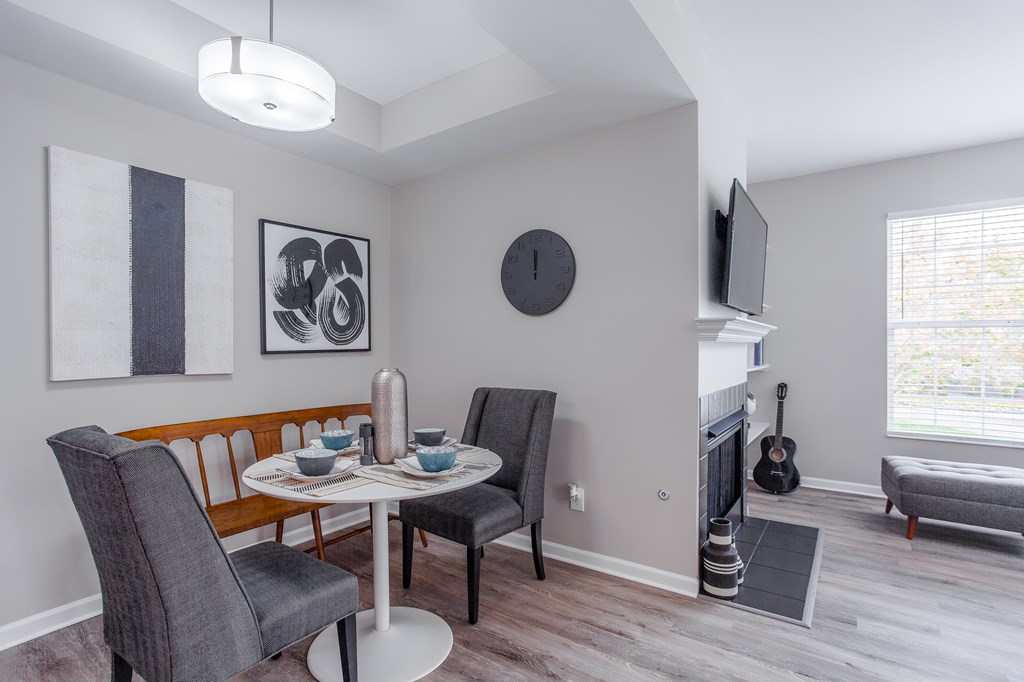 A dining room with a table set for two and a guitar leaning against the wall.
