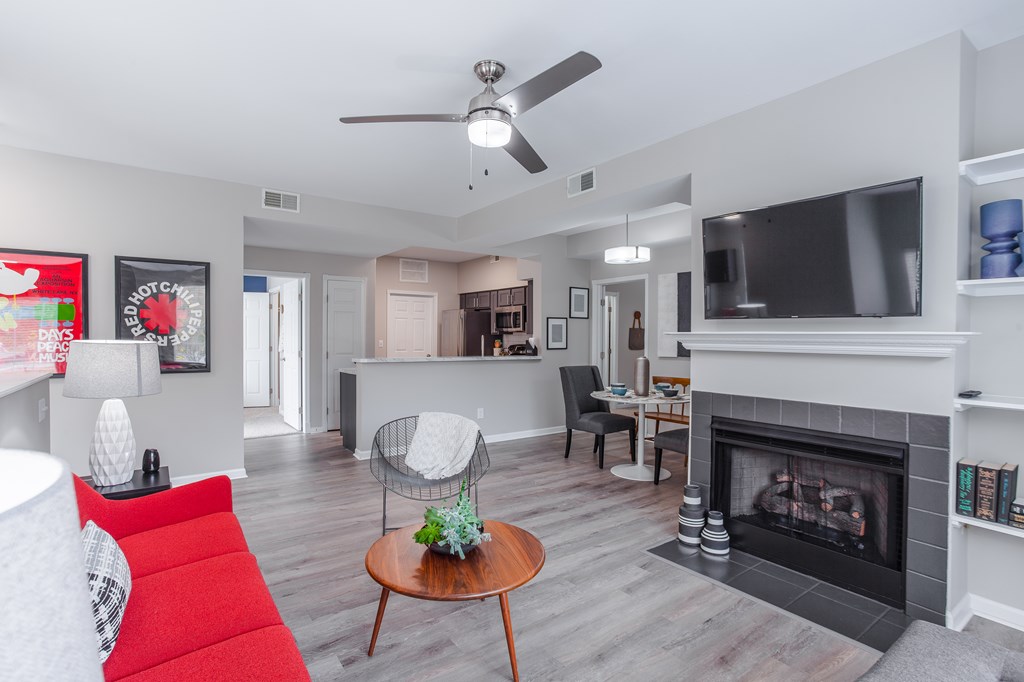 A living room with a red couch and a fireplace.