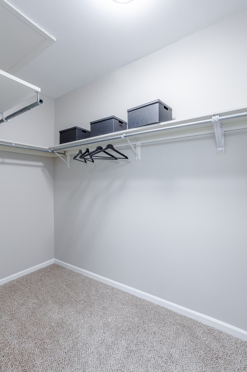 A white room with a shelf and two black boxes on it.