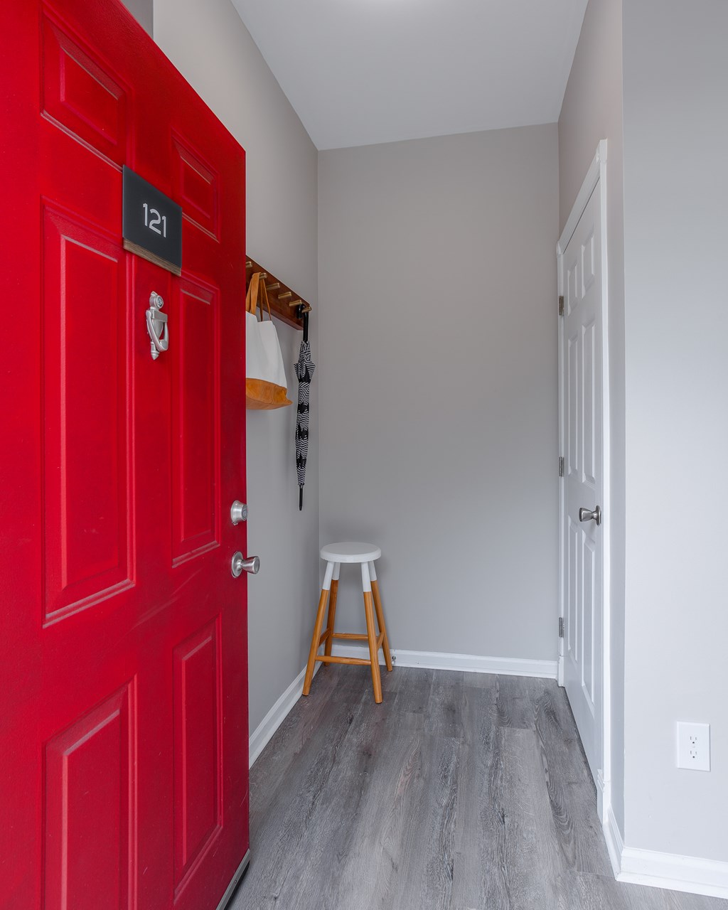 A red door with a number plate on it.