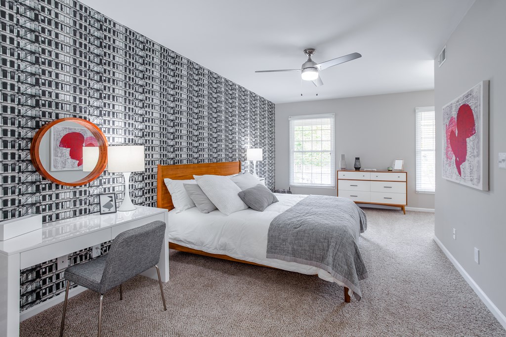 A bedroom with a bed, desk, and chair.