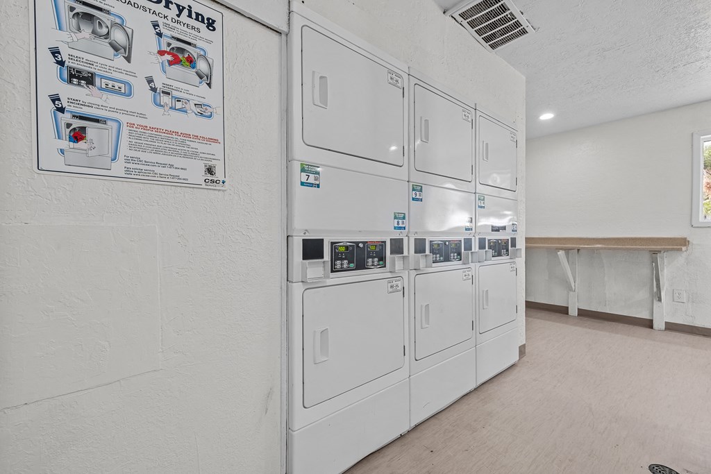 a white kitchen with a row of white refrigerators in it