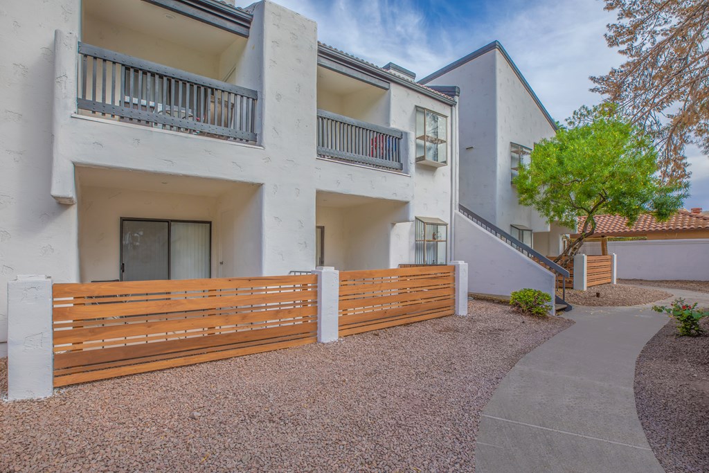 a white building with a wooden fence in front of it