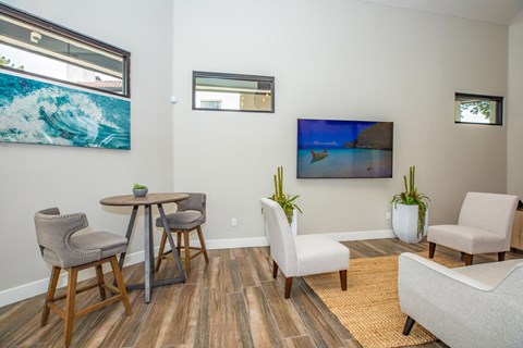 a living room with chairs and a table and a tv