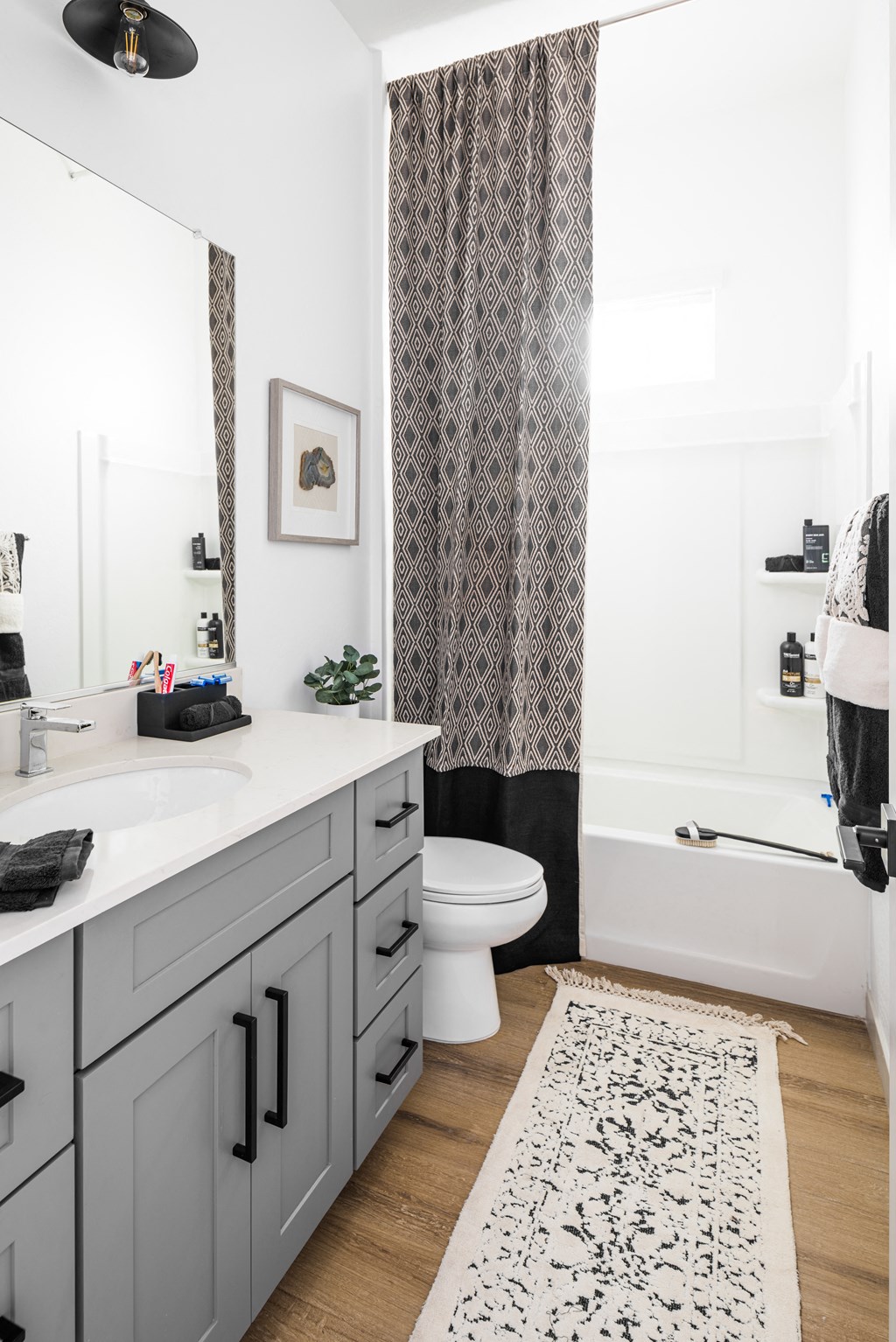 a bathroom with white walls and a black and white shower curtain
