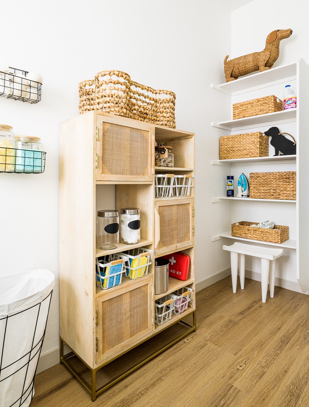 a storage unit with baskets and baskets on the shelves and a stool next to it