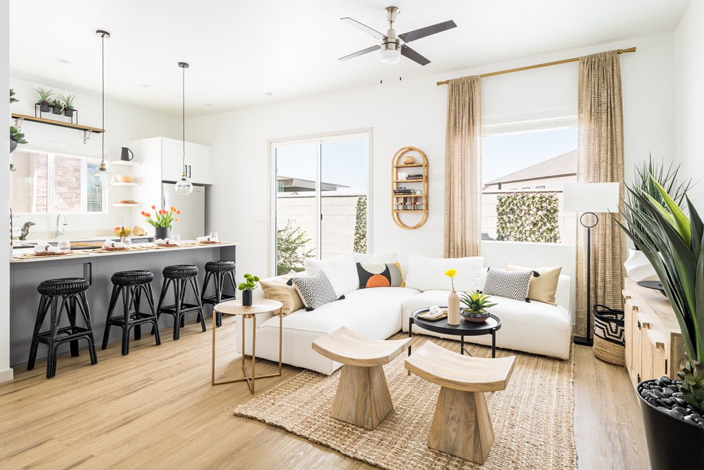 a living room and kitchen with white walls and wood floors
